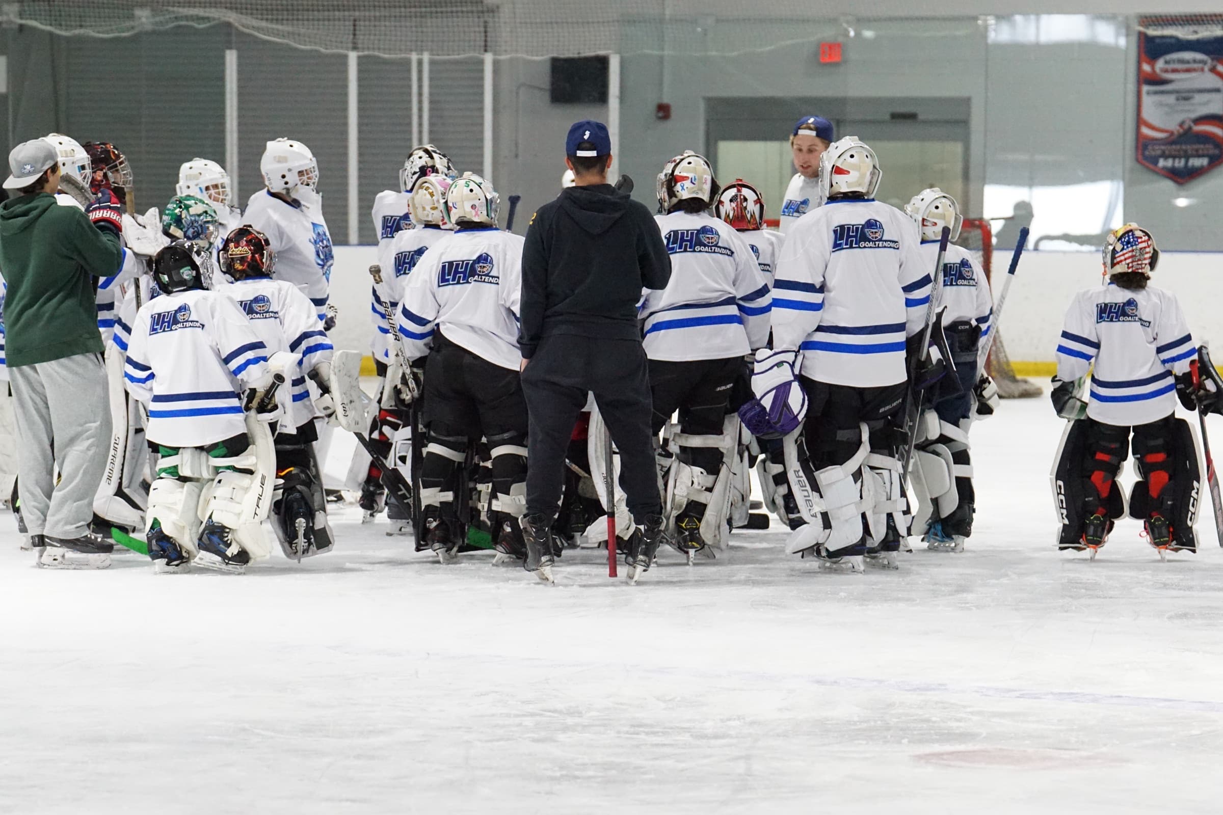 Coach addressing a group of LH Goaltending camp goalies on ice
