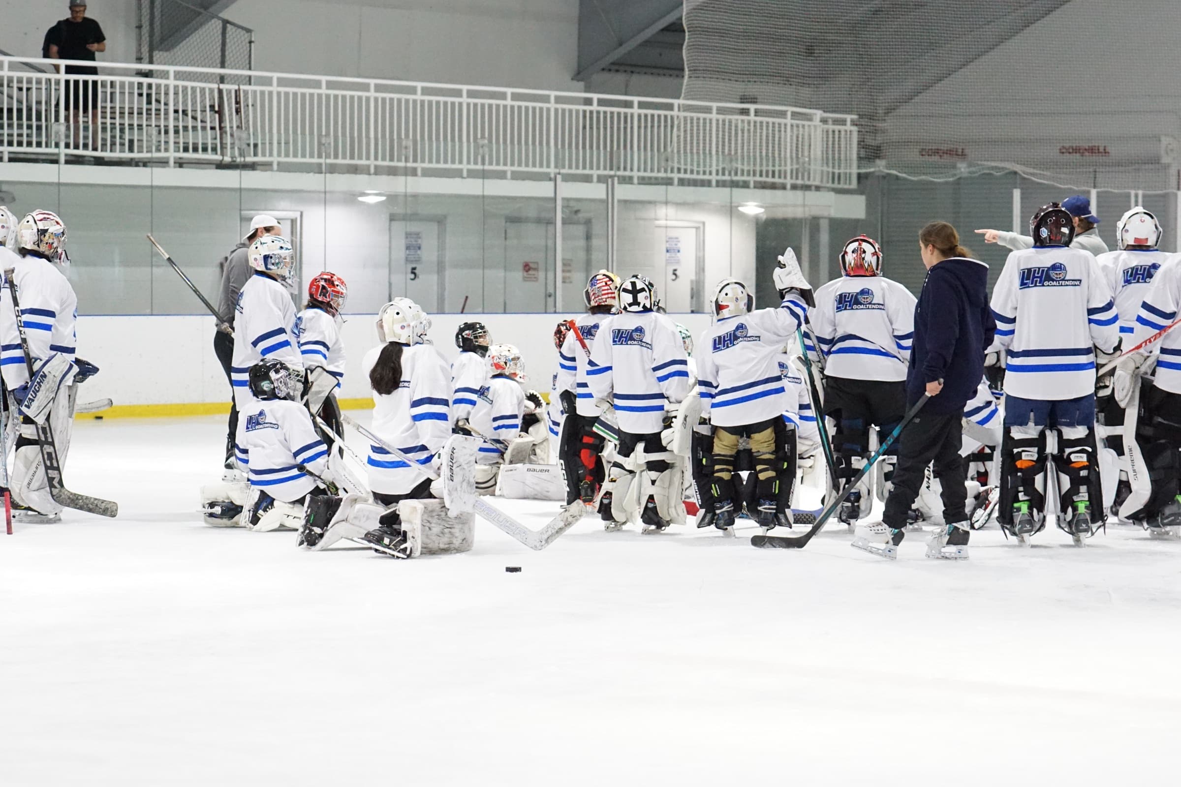 LH Goaltending camp group on ice with coach instructing