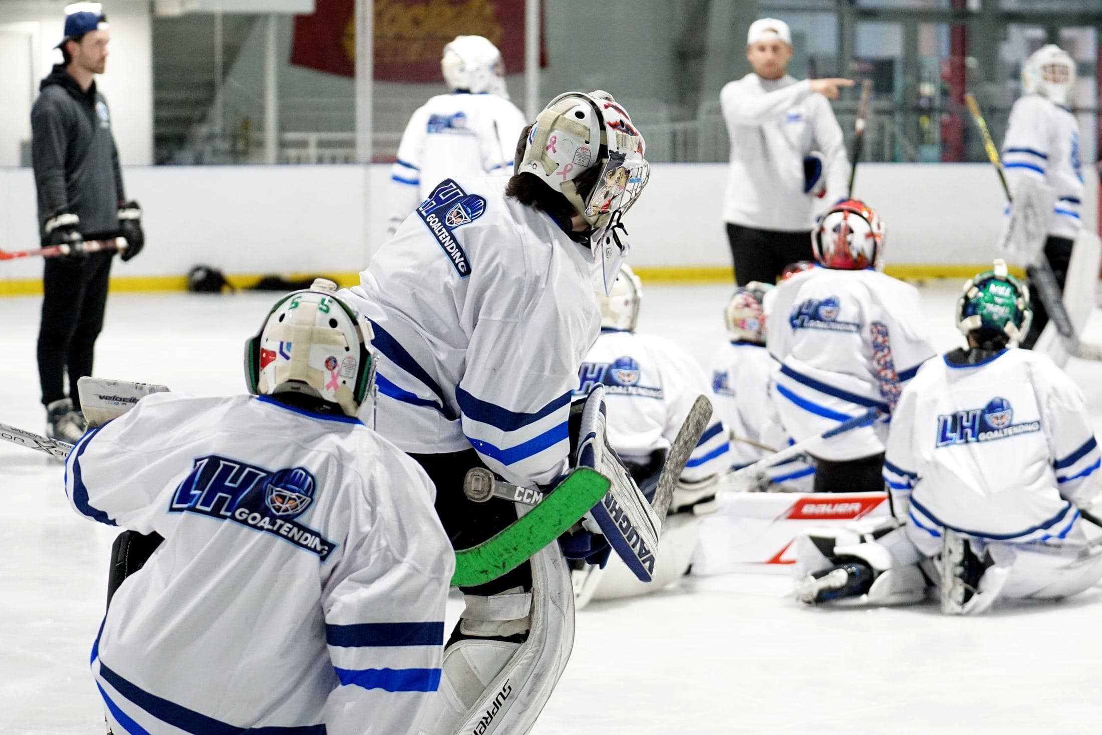 LH Goaltending camp group huddled on the ice around the coach